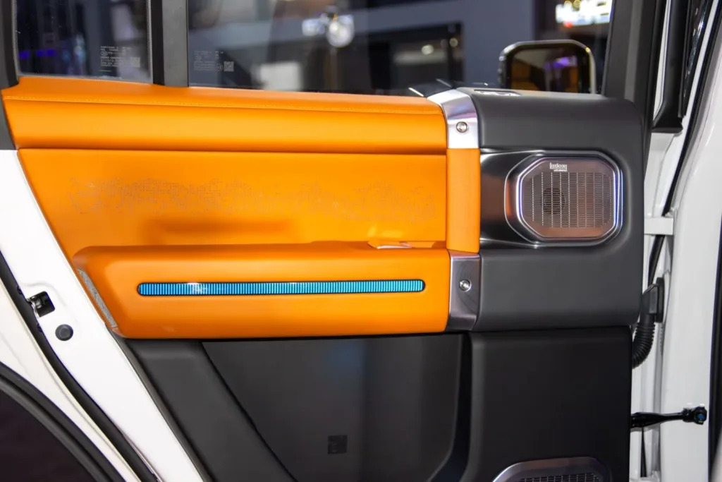 Car door panel with a built-in speaker and orange leather trim