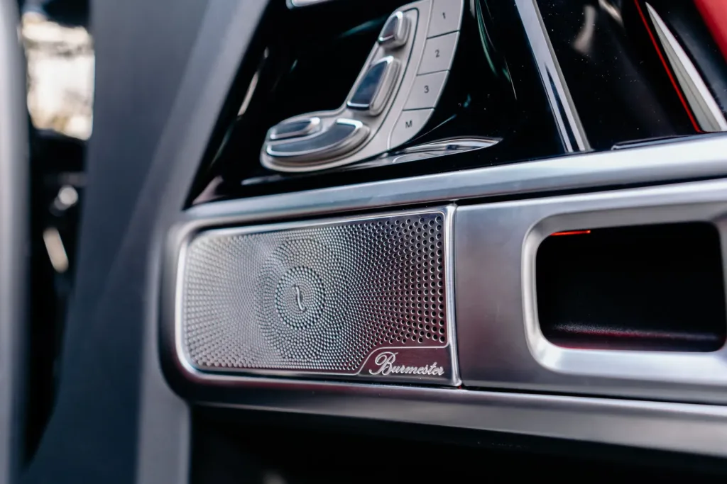Metal speaker grille set into a car door panel