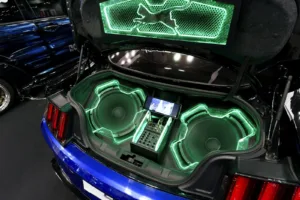 How to choose a subwoofer for your car: a trunk fitted with subwoofer enclosures under green neon light