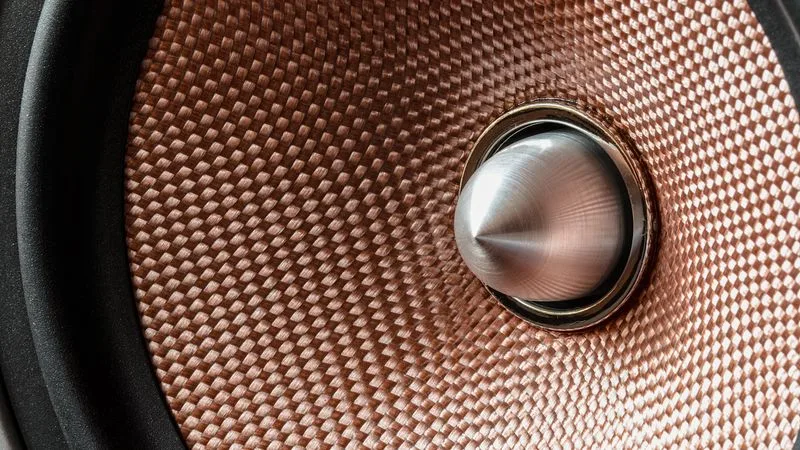 A car subwoofer mounted in a sealed enclosure in a vehicle boot