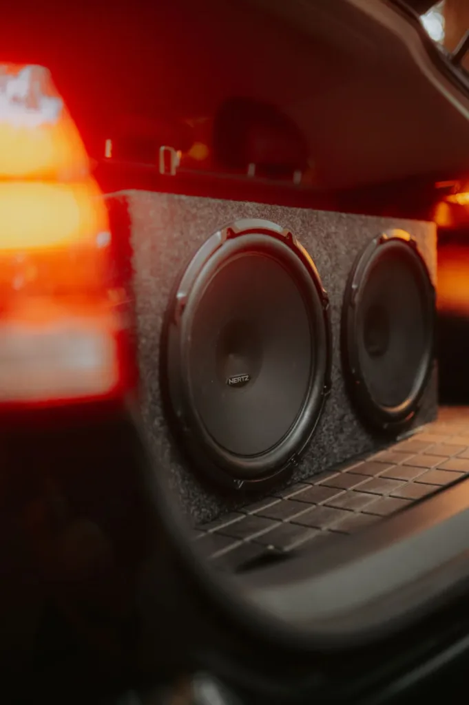 Two subwoofers mounted in a car trunk with accent lighting