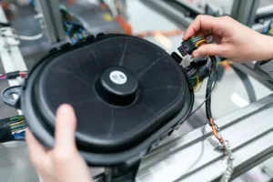 Technician working on a speaker assembly in a workshop