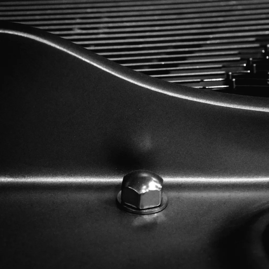 Close-up of a bolt on a metal panel, like a chassis ground point