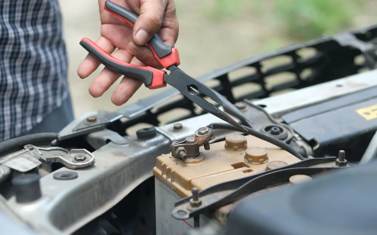 How to ground an amplifier in car: tightening a cable connection at the car battery