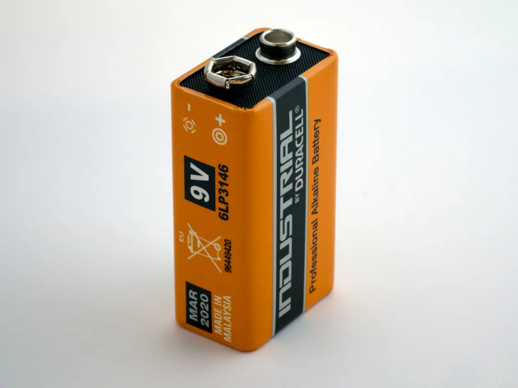 9-volt battery standing upright on a white surface